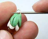 Awl poking through a wire loop on clay